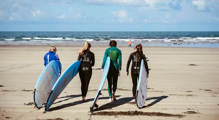 Surfers carrying surfboards on Strandhill Beach in County Sligo