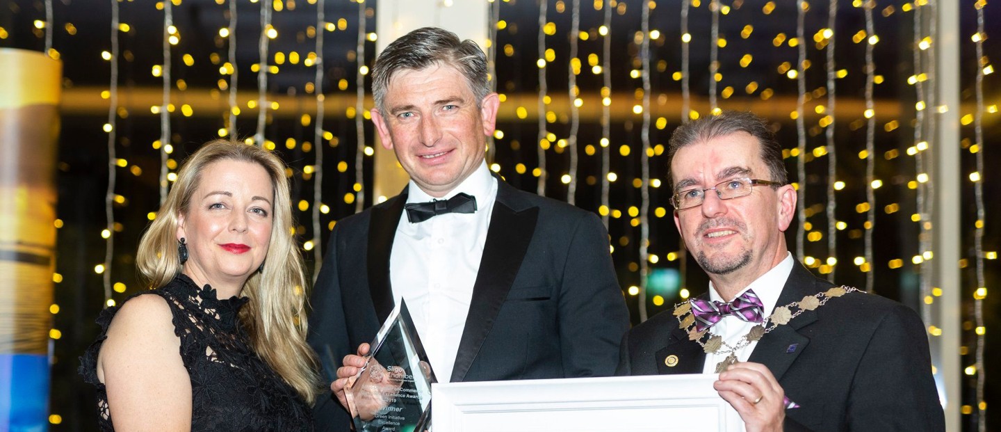 Three Voya representatives smiling proudly at an awards ceremony