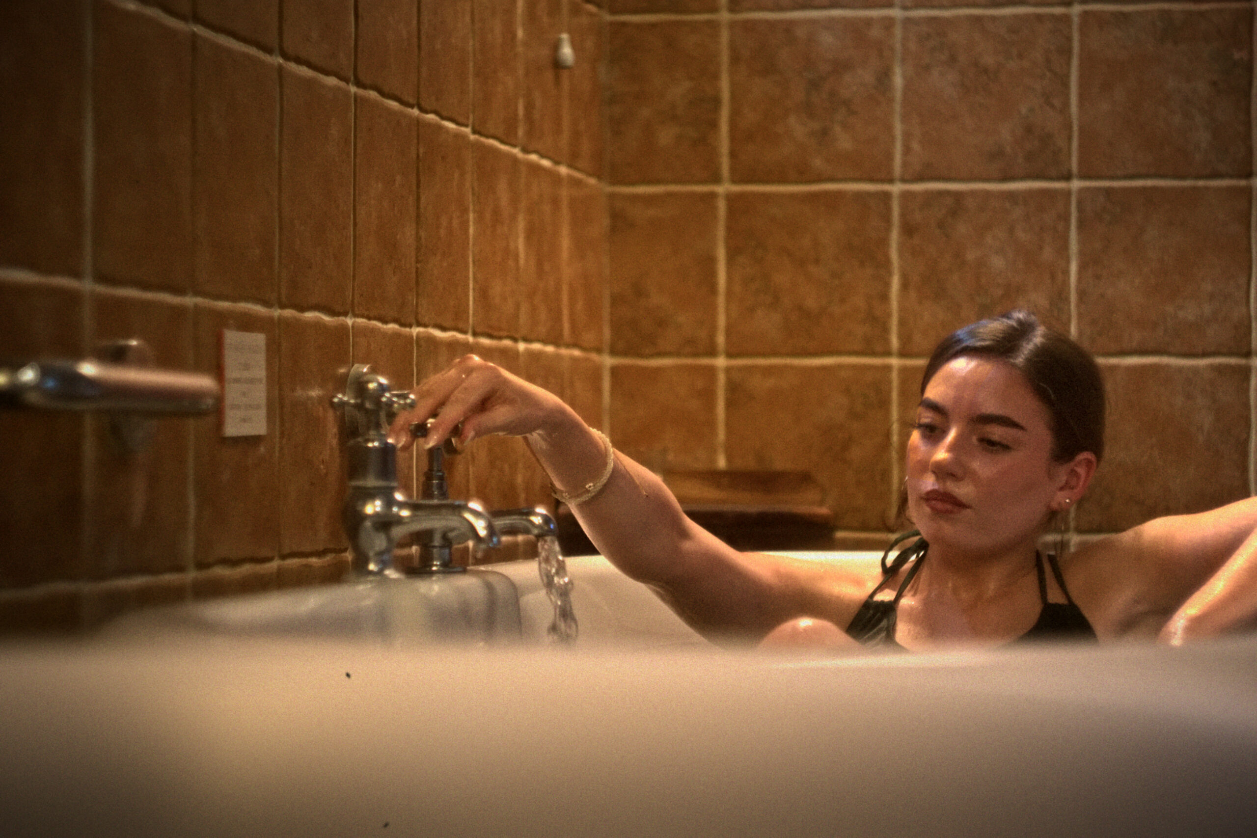 A woman turning on the water in a VOYA seaweed bath
