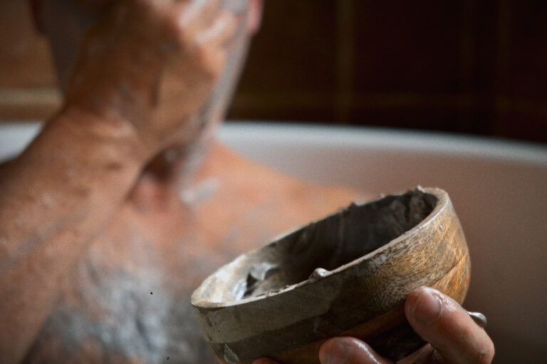 A man applying cream in a bathtub