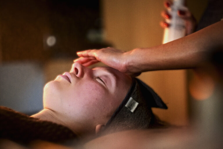 A woman relaxes as she receives a facial treatment at VOYA spa